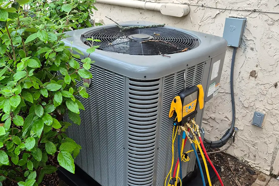 HVAC technician performing refrigerant pressure testing during AC maintenance in West Lafayette, IN