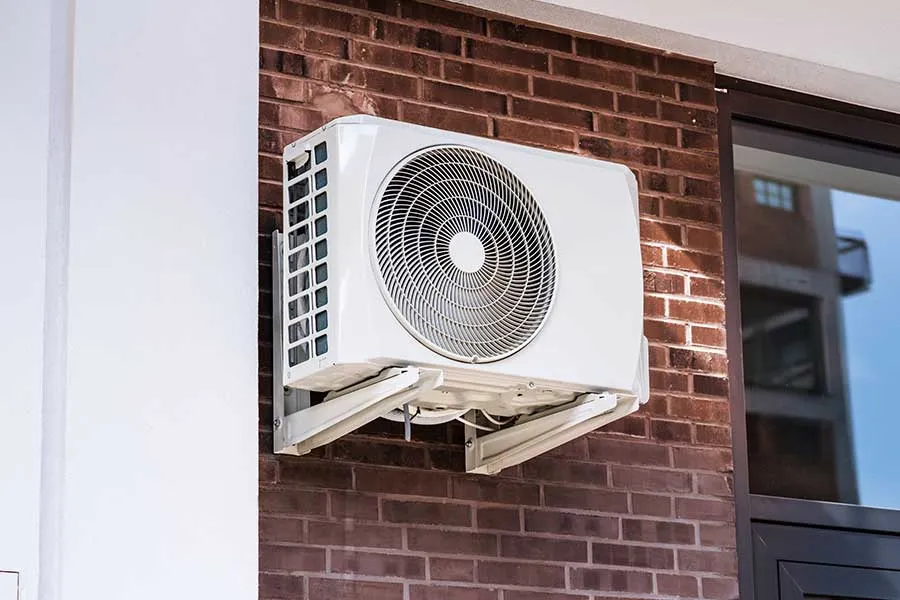 Outdoor condenser ready for ductless mini split maintenance beside a home